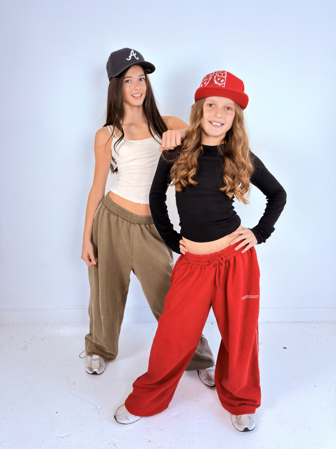 Two models styling black and red customised caps